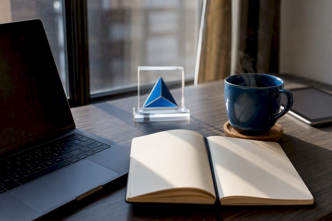 Workspace with laptop, coffee, and Blue Prysm logo